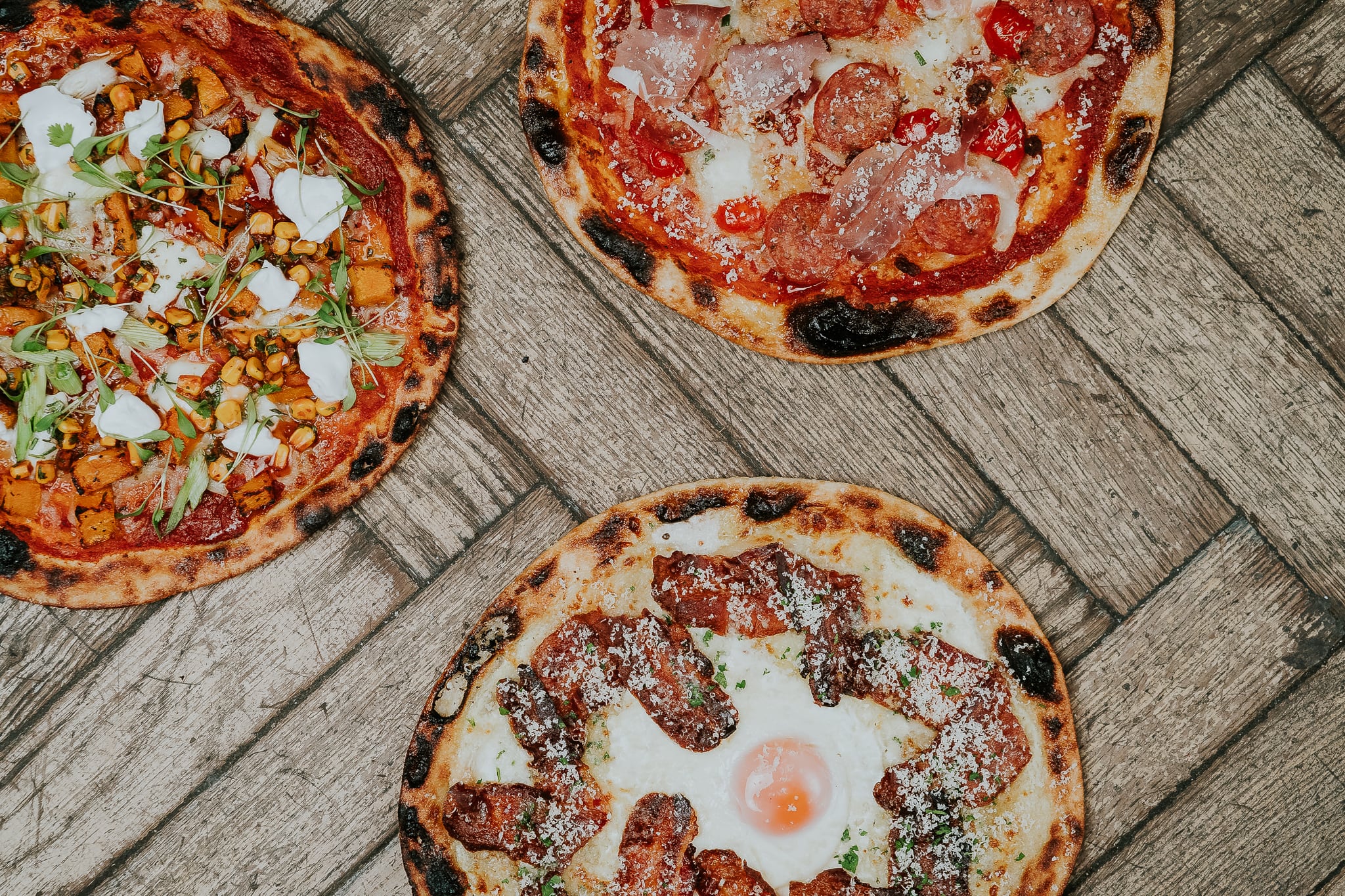 Freshly baked pizzas placed on a wooden table